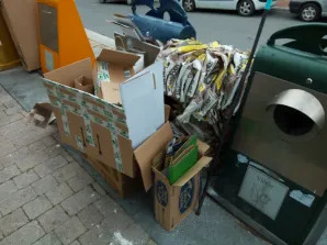 Contenedor de papel desbordado con residuos acumulados alrededor en Cuéllar